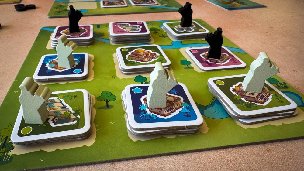 Architects of Amytis board game components and tile layout<br />
Architects of Amytis 3x3 city grid with stacked tiles<br />
Architects of Amytis favor board and pattern cards