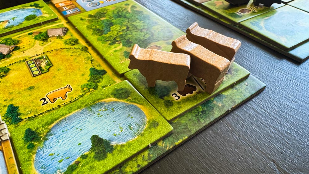 Black Forest board game components showing resource wheels, wooden meeples, and medieval artwork by Uwe Rosenberg