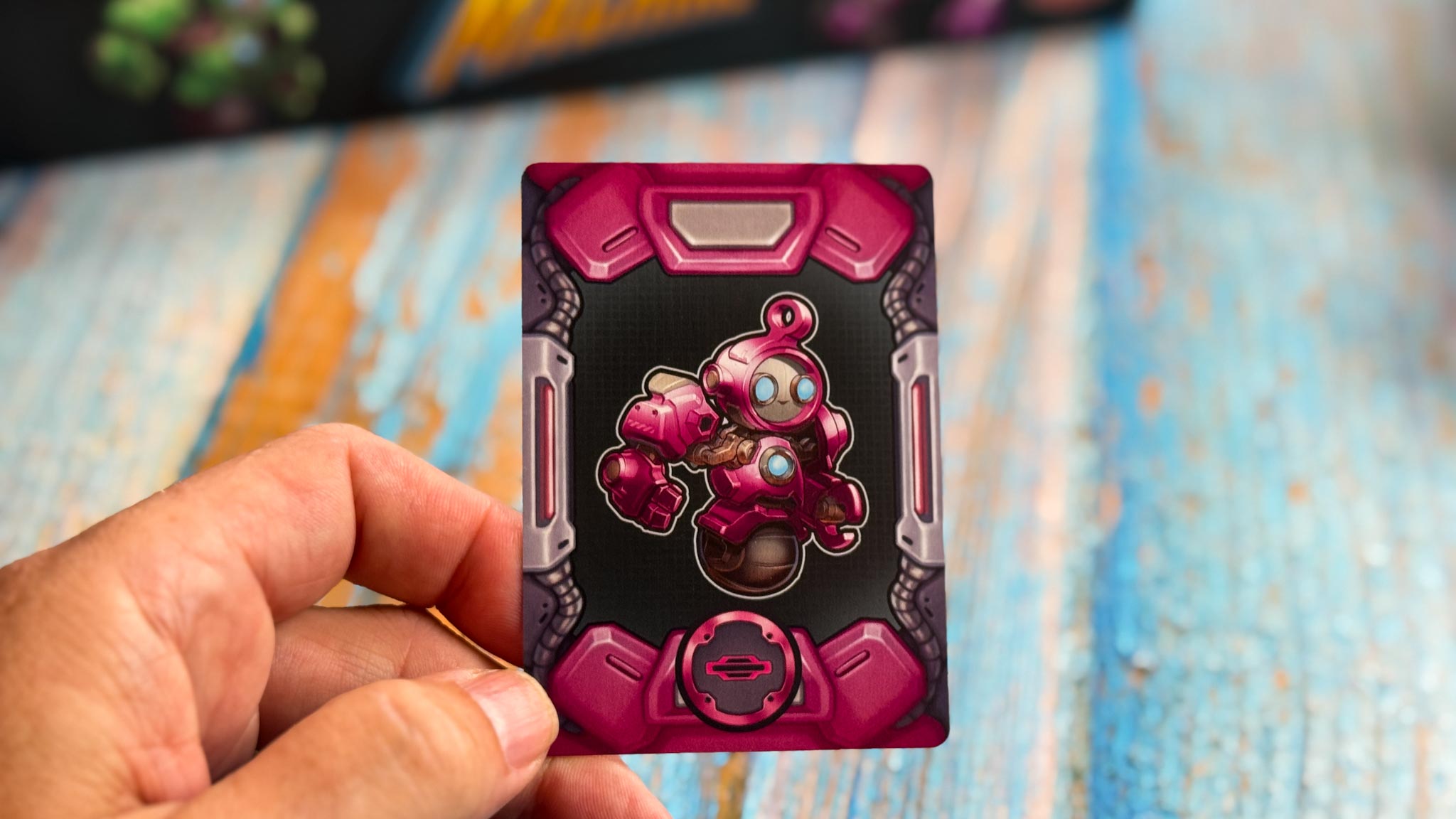 Colorful geometric robot pieces from Into the Machine board game arranged on conveyor belt game board