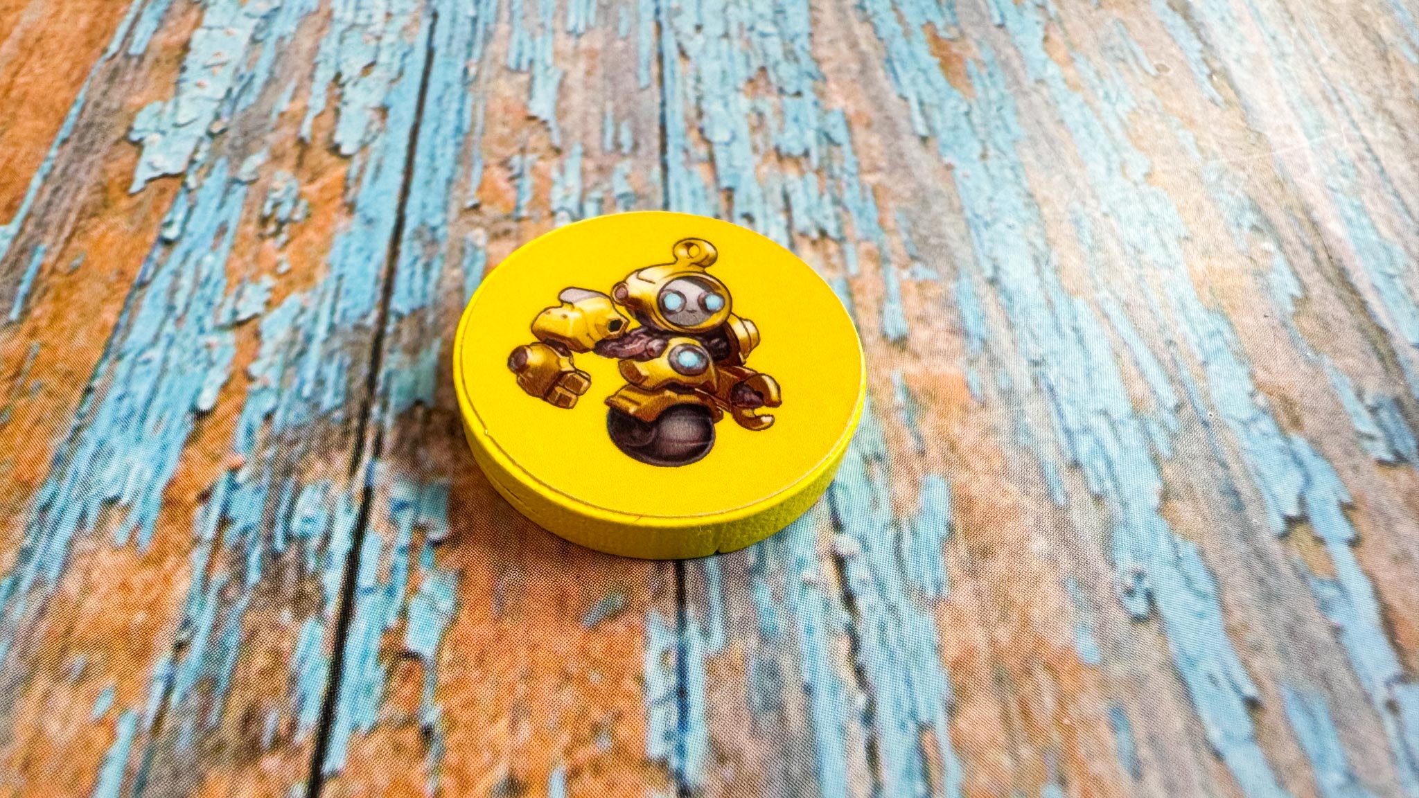 Colorful geometric robot pieces from Into the Machine board game arranged on conveyor belt game board