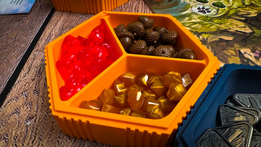 Colorful geometric robot pieces from Into the Machine board game arranged on conveyor belt game board