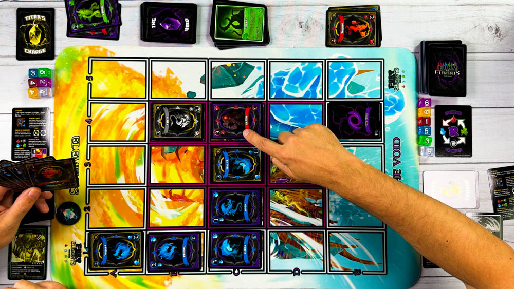 Fury of the Elements board game components showing elemental cards with directional arrows on neoprene play mat