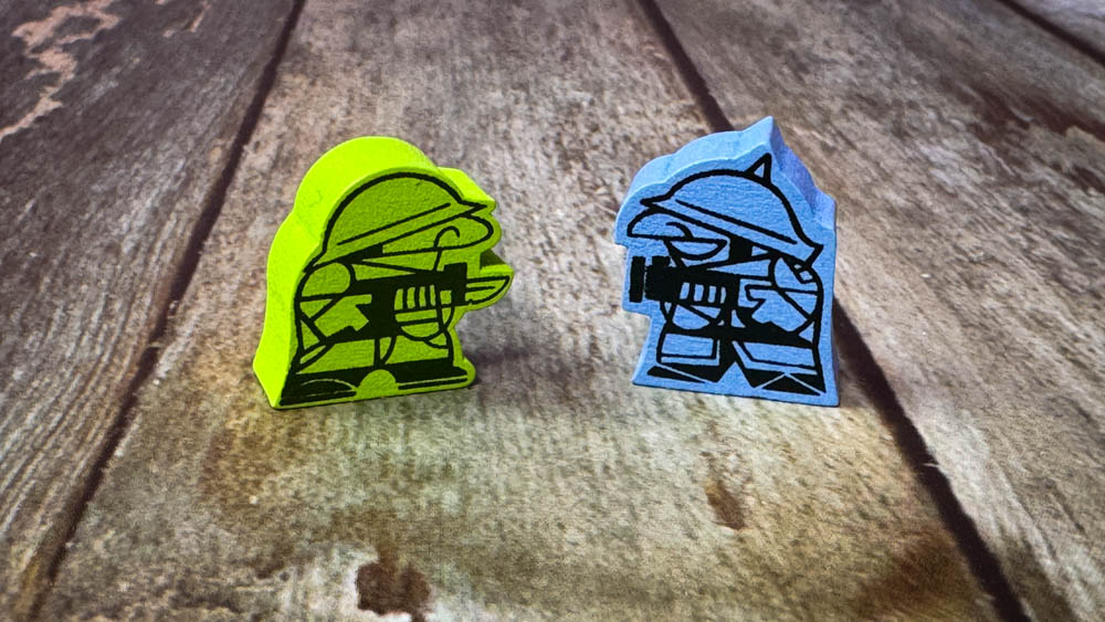 Gruntz board game components showing wooden meeples, magnetic vehicle attachments, and compact game board with WWII tactical gameplay elements