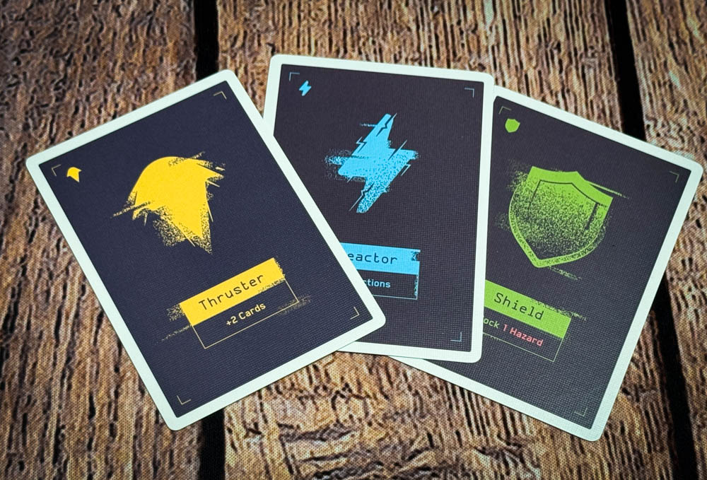 Moonrakers board game review showing deck building cards, contract missions, and player boards with ship upgrades in a space mercenary setting