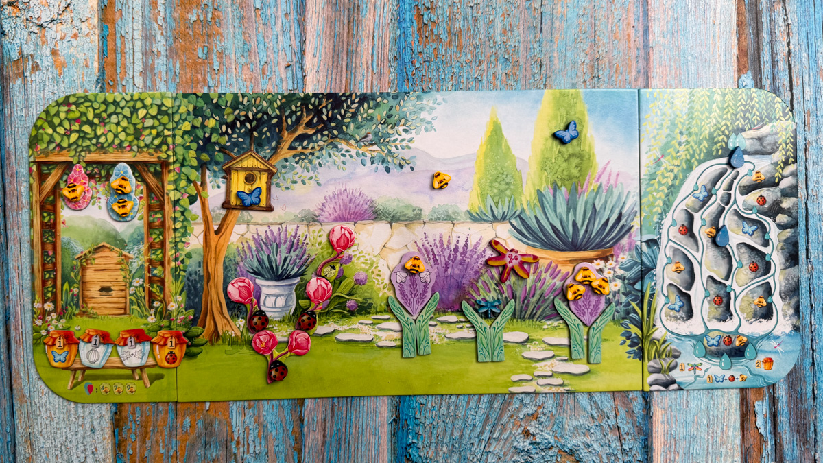 A close-up of the colorful wooden insect and frog tokens from the Pergola board game.
